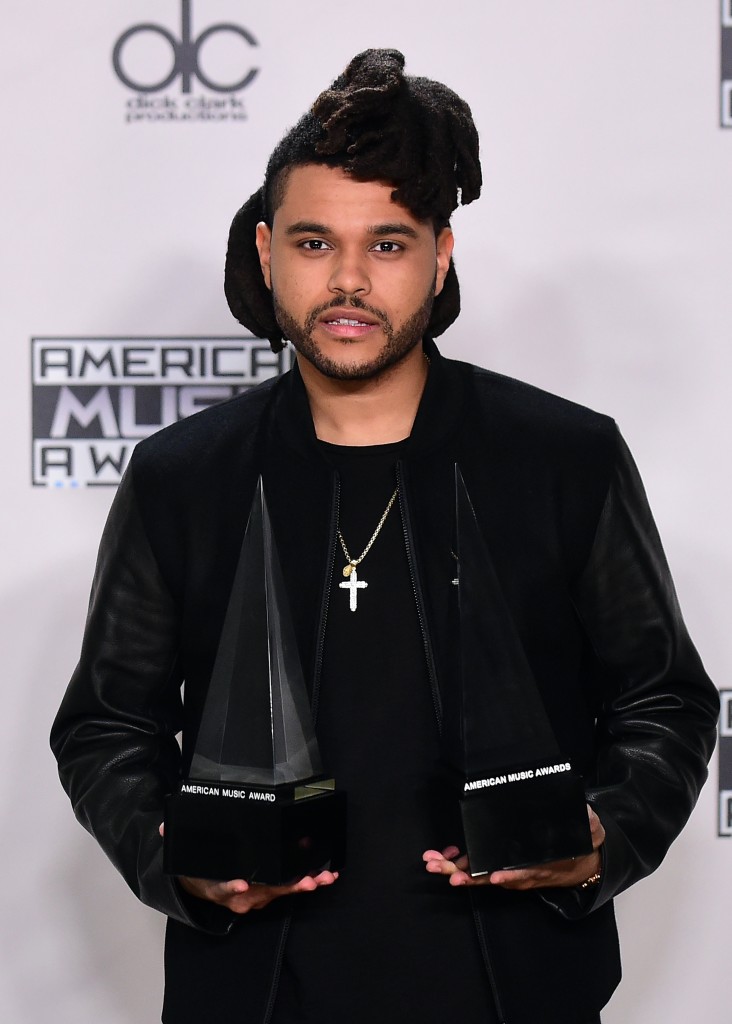 The Weeknd poses with his award at the 2015 American Music Awards in Los Angeles, California on November 22, 2015. AFP PHOTO / FREDERIC J. BROWN / AFP / FREDERIC J. BROWN