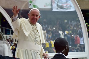 Pope Francis waves from his "Popemobile" as he arrives at the Kasarani Stadium in Nairobi on November 27, 2015 for a meeting with youths.  Pope Francis lashed out at wealthy minorities who hoard resources at the expense of the poor as he visited a crowded slum in the Kenyan capital. "These are wounds inflicted by minorities who cling to power and wealth, who selfishly squander while a growing majority is forced to flee to abandoned, filthy and run-down peripheries," the 78-year-old pontiff told crowds in the Nairobi shanty town of Kangemi.  AFP PHOTO / GIUSEPPE CACACE / AFP / GIUSEPPE CACACE