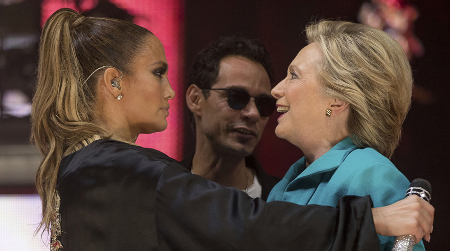 Democratic presidential candidate Hillary Clinton, right, accompanied by singer-songwriter Marc Anthony, center, hugs performer Jennifer Lopez, left, at a Get Out The Vote performance at Bayfront Park Amphitheater in Miami, Saturday, Oct. 29, 2016. (AP Photo/Andrew Harnik)