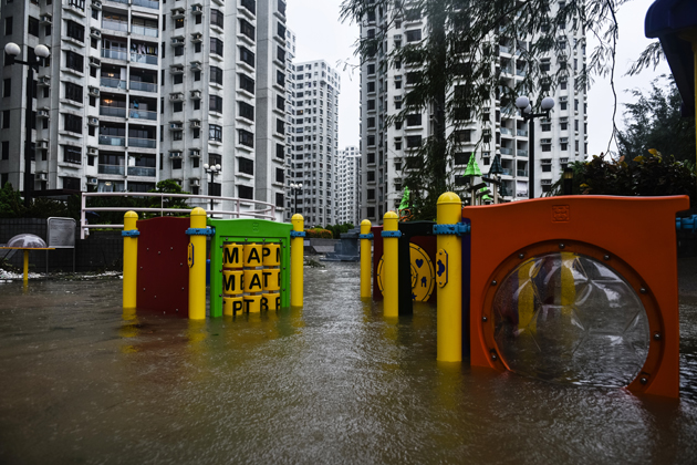 A flooded playground is seen in front of residential blocks after heavy rains brought on by Typhoon Hato in Hong Kong on August 23, 2017. Typhoon Hato left three dead in the gambling hub of Macau on August 23 as it brought chaos and destruction to the enclave after sweeping through neighbouring Hong Kong, where one man also died. / AFP PHOTO / Anthony WALLACE