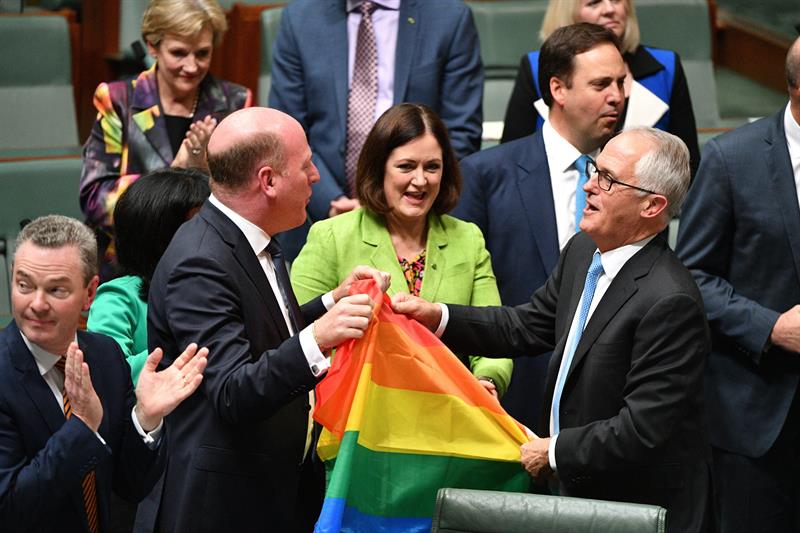 El primer ministro australiano, Malcolm Turnbull (d), y el liberal Trent Zimmerman (c-i) celebran la aprobación del matrimonio entre personas del mismo sexo en el Parlamento en Canberra (Australia). Foto: EFE