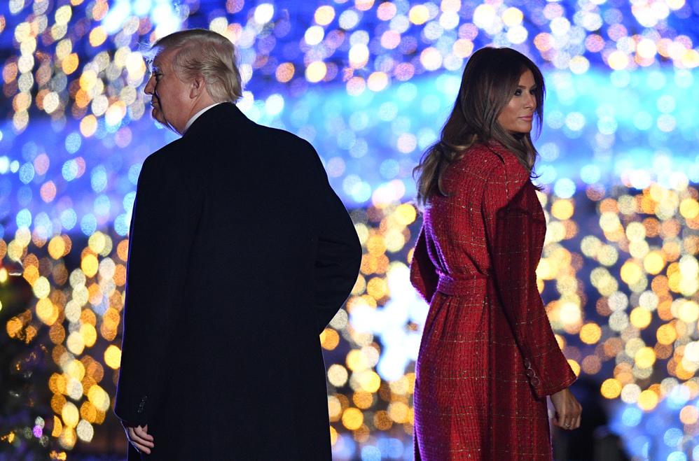 US President Donald Trump and First Lady Melania Trump walk on the stage during the 95th annual National Christmas Tree Lighting ceremony at the Ellipse in President's Park near the White House in Washington, DC on November 30, 2017. / AFP PHOTO / JIM WATSON