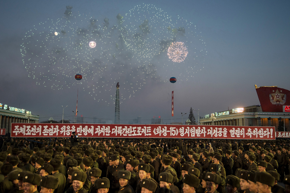 North Korean soldiers watch a fireworks display put on to celebrate the North's declaration on November 29 it had achieved full nuclear statehood, during a mass rally on Kim Il-Sung Square in Pyongyang on December 1, 2017. North Korea's leader Kim Jong-Un declared the country had achieved a "historic cause" of becoming a nuclear state, its state media said on November 29, after the country tested an intercontinental ballistic missile earlier in the day. / AFP PHOTO / Kim Won-Jin