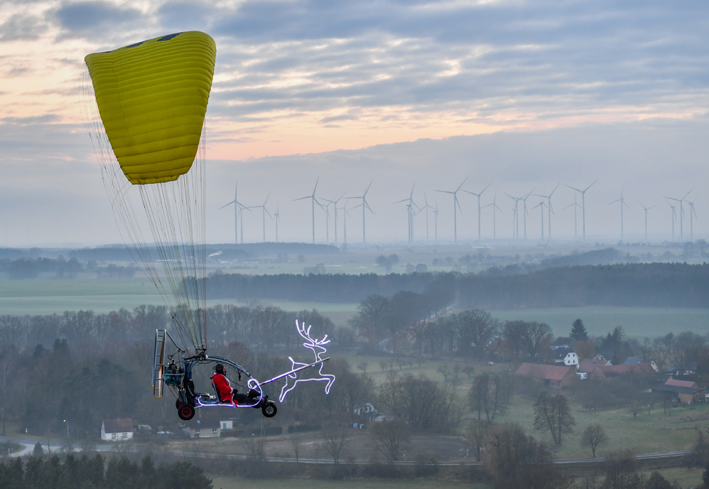 A man, disguised as Santa Claus, flies in a microlight on December 2, 2017 near Sieversdorf, eastern Germany. / AFP PHOTO / dpa / Patrick Pleul / Germany OUT