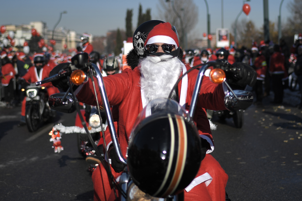 A man dressed as Santa Claus rides a motorbike during the 8th edition of the Santa Claus 'Papa Noel' rally on December 3, 2017 in Turin. Around twenty thousands people took part in the charity event for the Regina Margherita Children Hospital. / AFP PHOTO / Marco BERTORELLO