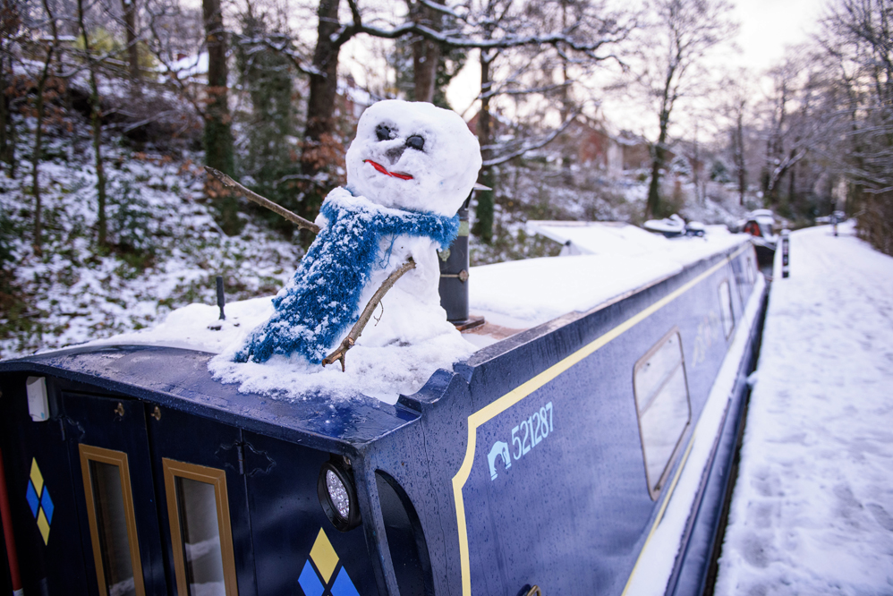 A snow man sits on a canal boat on the Llangollen canal in the town of Llangollen in north Wales, on December 8, 2017, as Storm Caroline plunges temperatures across the UK. / AFP PHOTO / Phil HATCHER-MOORE
