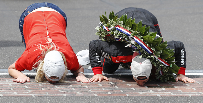 KSK038. Indinapolis (United States), 27/05/2018.- Australian driver Will Power (R) of Team Penske and his wife Liz Cannon (L) kiss the bricks at the finish line after he won the 102nd running of the Indianapolis 500 auto race at the Indianapolis Motor Speedway in Indianapolis, Indiana, USA, 27 May 2018. (Estados Unidos) EFE/EPA/KAMIL KRZACZYNSKI
