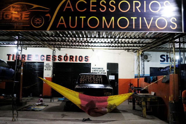 Venezuelan man sleeps on a hammock during the night at the car repair shop, near the interstate Bus Station in Boa Vista, Roraima state, Brazil August 24, 2018. Picture taken August 24, 2018. REUTERS/Nacho Doce