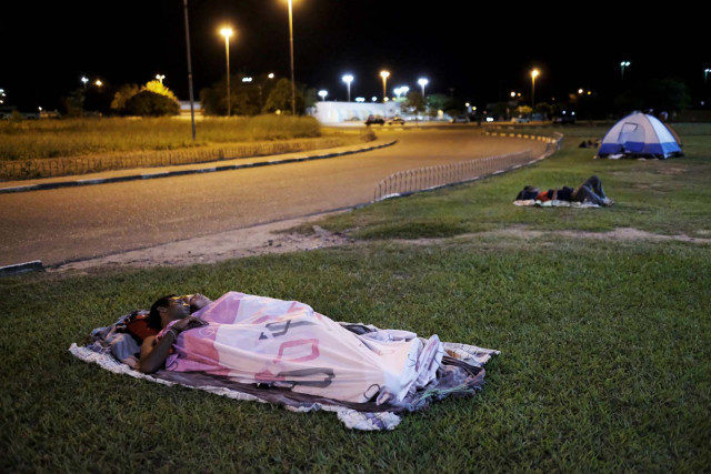 Venezuelan people sleep on the grass in front of interstate Bus Station in Boa Vista, Roraima state, Brazil August 23, 2018. Picture taken Auguist 23, 2018. REUTERS/Nacho Doce