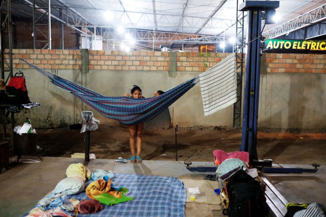 Venezuelan women are pictured near their improvised beds during the night at the car repair shop, near the interstate Bus Station in Boa Vista, Roraima state, Brazil August 24, 2018. Picture taken August 24, 2018. REUTERS/Nacho Doce