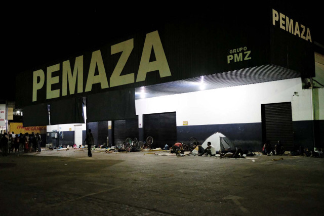 Venezuelan people rest during the night in a spare parts shop for cars and motorbikes, near the interstate Bus Station in Boa Vista, Roraima state, Brazil August 24, 2018. Picture taken August 24, 2018. REUTERS/Nacho Doce