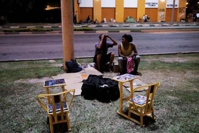 Venezuelan men talks on the grass in front of interstate Bus Station in Boa Vista, Roraima state, Brazil August 25, 2018. Picture taken August 25, 2018. REUTERS/Nacho Doce