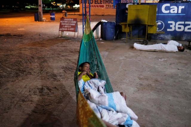 Venezuelan boy sleeps on a hammock during the night at the car repair shop, near the interstate Bus Station in Boa Vista, Roraima state, Brazil August 25, 2018. Picture taken August 25, 2018. REUTERS/Nacho Doce