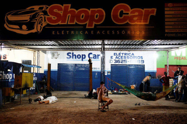 Venezuelan people are pictured near their improvised beds during the night at the car repair shop, near the interstate Bus Station in Boa Vista, Roraima state, Brazil August 25, 2018. Picture taken August 25, 2018. REUTERS/Nacho Doce