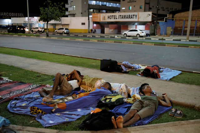 Venezuelan men sleep on the grass in front of interstate Bus Station in Boa Vista, Roraima state, Brazil August 24, 2018. Picture taken August 24, 2018. REUTERS/Nacho Doce
