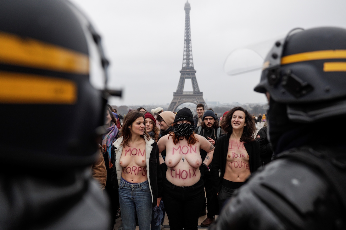 Members of the "Witch Bloc" feminist group, some of them bare chested, demonstrate behind riot police as they came to disturb the pro-life movement 13th "March for Life" (Marche pour la vie) anti-abortion rally in Paris on January 20, 2019. (Photo by Geoffroy VAN DER HASSELT / AFP)