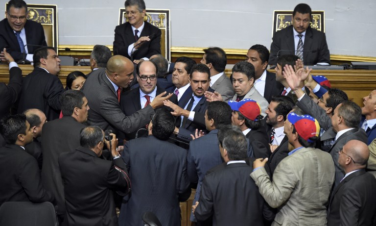 Newly elected opposition deputy Julio Borges (C) and governement deputy Hector Rodriguez (2nd L) argue during the new parliament's swearing-in ceremony in Caracas, on January 5, 2016. Venezuela's President Nicolas Maduro ordered the security forces to ensure the swearing-in of a new opposition-dominated legislature passes off peacefully Tuesday, after calls for rallies raised fears of unrest. AFP PHOTO/JUAN BARRETO / AFP / JUAN BARRETO