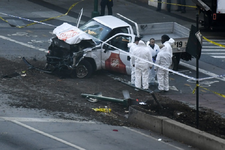 Investigators inspect a truck following a shooting incident in New York on October 31, 2017.  Several people were killed and numerous others injured in New York on Tuesday after a vehicle plowed into a pedestrian and bike path in Lower Manhattan, police said. "The vehicle struck multiple people on the path," police tweeted. "The vehicle continued south striking another vehicle. The suspect exited the vehicle displaying imitation firearms & was shot by NYPD." / AFP PHOTO / DON EMMERT