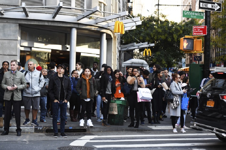People watch as police officers secure an area following a shooting incident in New York on October 31, 2017.  Several people were killed and numerous others injured in New York on Tuesday after a vehicle plowed into a pedestrian and bike path in Lower Manhattan, police said. "The vehicle struck multiple people on the path," police tweeted. "The vehicle continued south striking another vehicle. The suspect exited the vehicle displaying imitation firearms & was shot by NYPD."  / AFP PHOTO / Don EMMERT