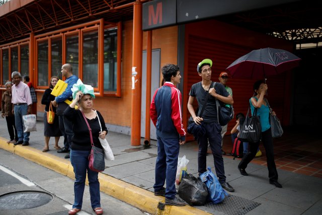 People wait for transportation in front of a closed metro station during a blackout in Caracas, Venezuela July 31, 2018. REUTERS/Carlos Garcia Rawlins