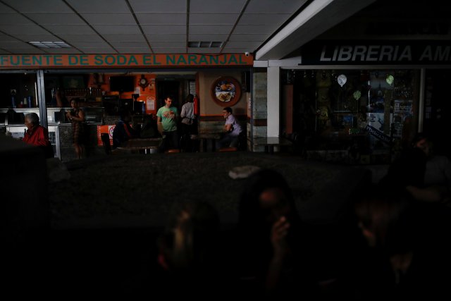 People speak in front of a restaurant at a shopping mall as they wait for the power to be restored during a blackout in Caracas, Venezuela July 31, 2018. REUTERS/Carlos Garcia Rawlins