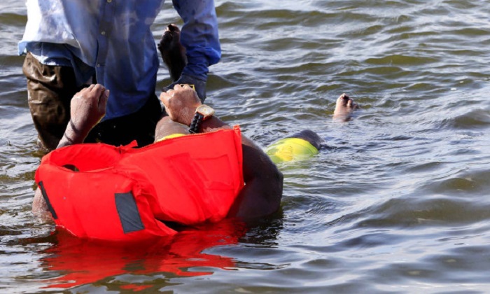 ATTENTION EDITORS - VISUAL COVERAGE OF SCENES OF INJURY OR DEATH   A volunteer retrieves a body of a passenger who died after a cruise boat capsized in Lake Victoria off Mukono district, Uganda November 25, 2018. REUTERS/James Akena  TEMPLATE OUT