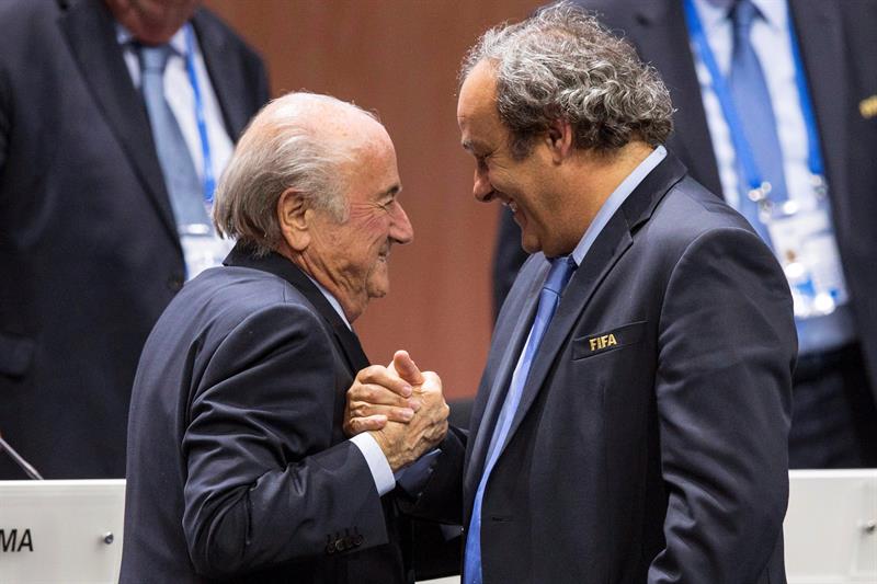 Foto de archivo del entonces presidente de la UEFA Michel Platini (dcha) mientras estrecha la mano al responsable de la FIFA Joseph S. Blatter (izq) tras su elección como presidente en Zúrich (Suiza) el 29 de mayo de 2015. Foto: EFE