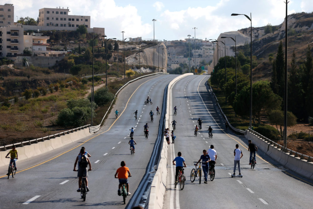 Niños circulan en bicicleta en una carretera vacía de Jerusalén. Foto: REUTERS/Ammar Awad